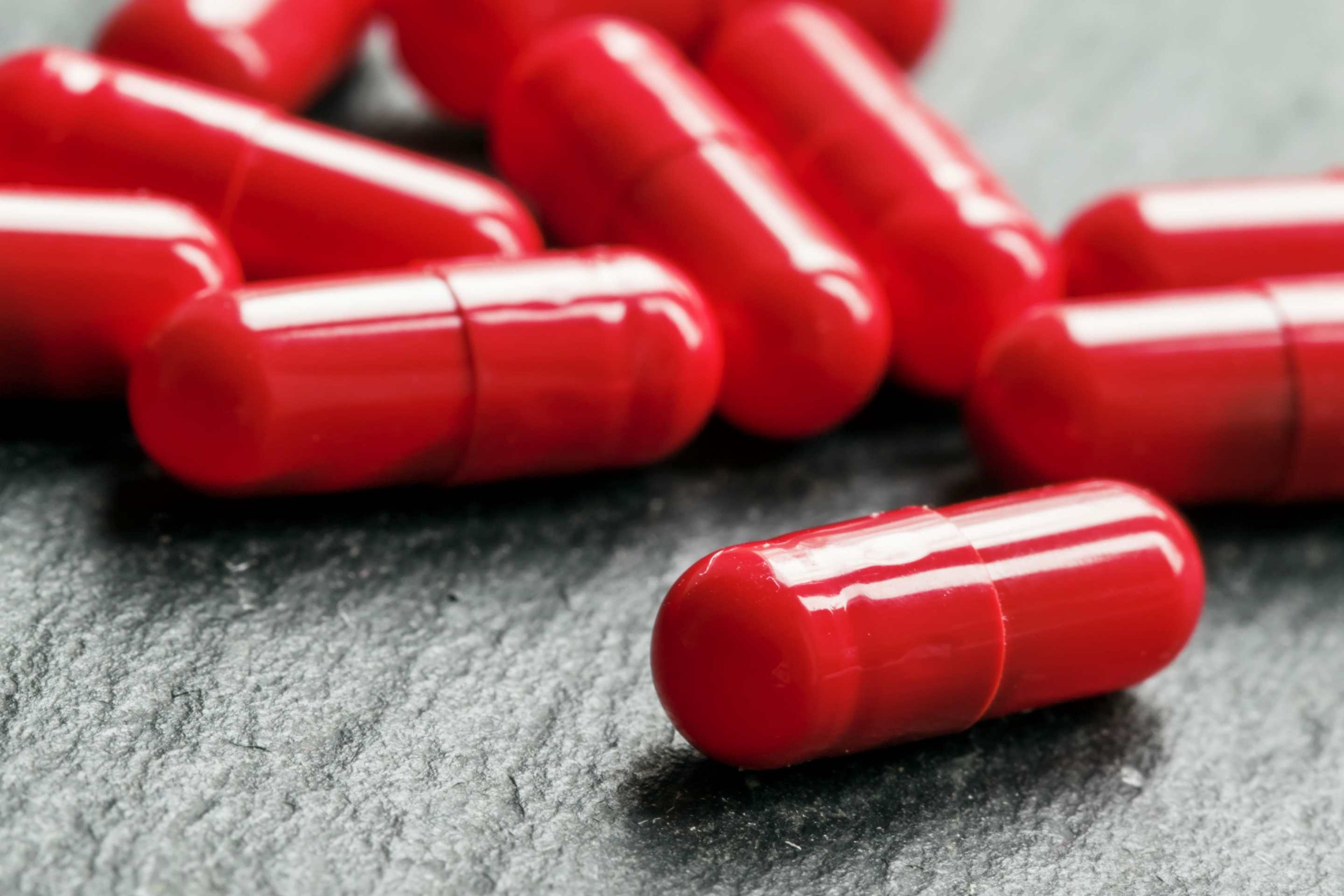 Scattered red pill capsules.