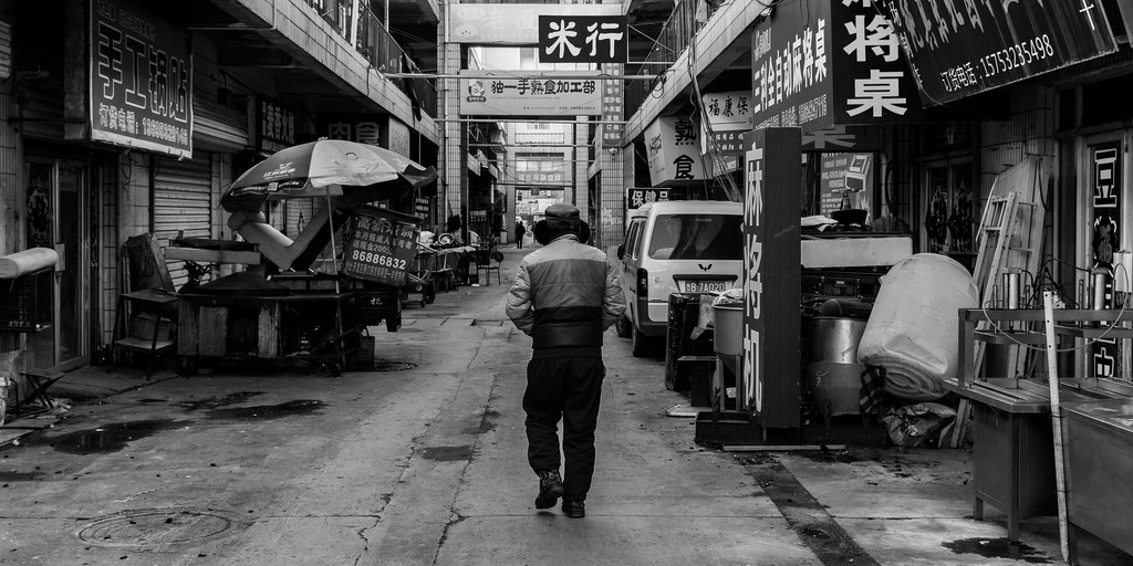 Man walking down street or alleyway.