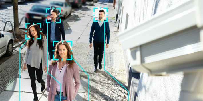 people walking on the street as cameras scan their faces