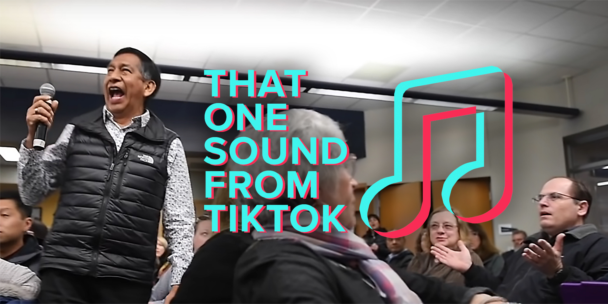 A man holding a microphone in front of a group of people.