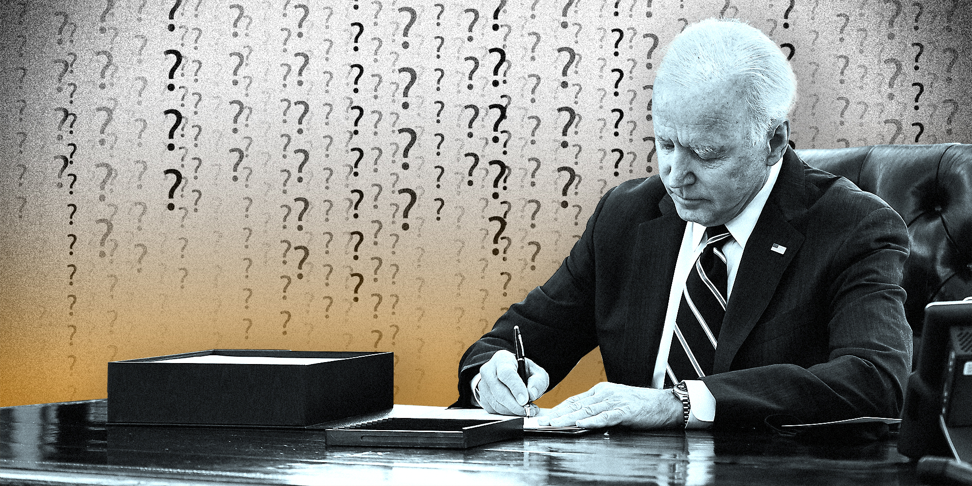 President Joe Biden signing a paper on a desk.