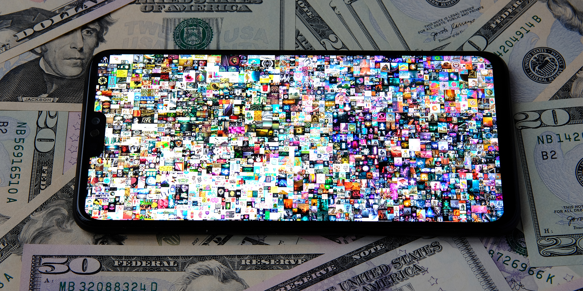 Smartphone with Beeple " EVERYDAYS: THE FIRST 5000 DAYS" collage art signed with NFT token seen on the screen placed on the dollars.