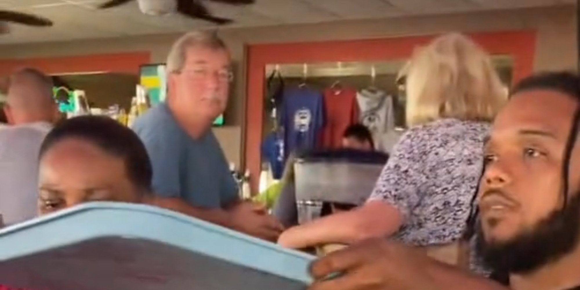 white man staring at Black family while they eat