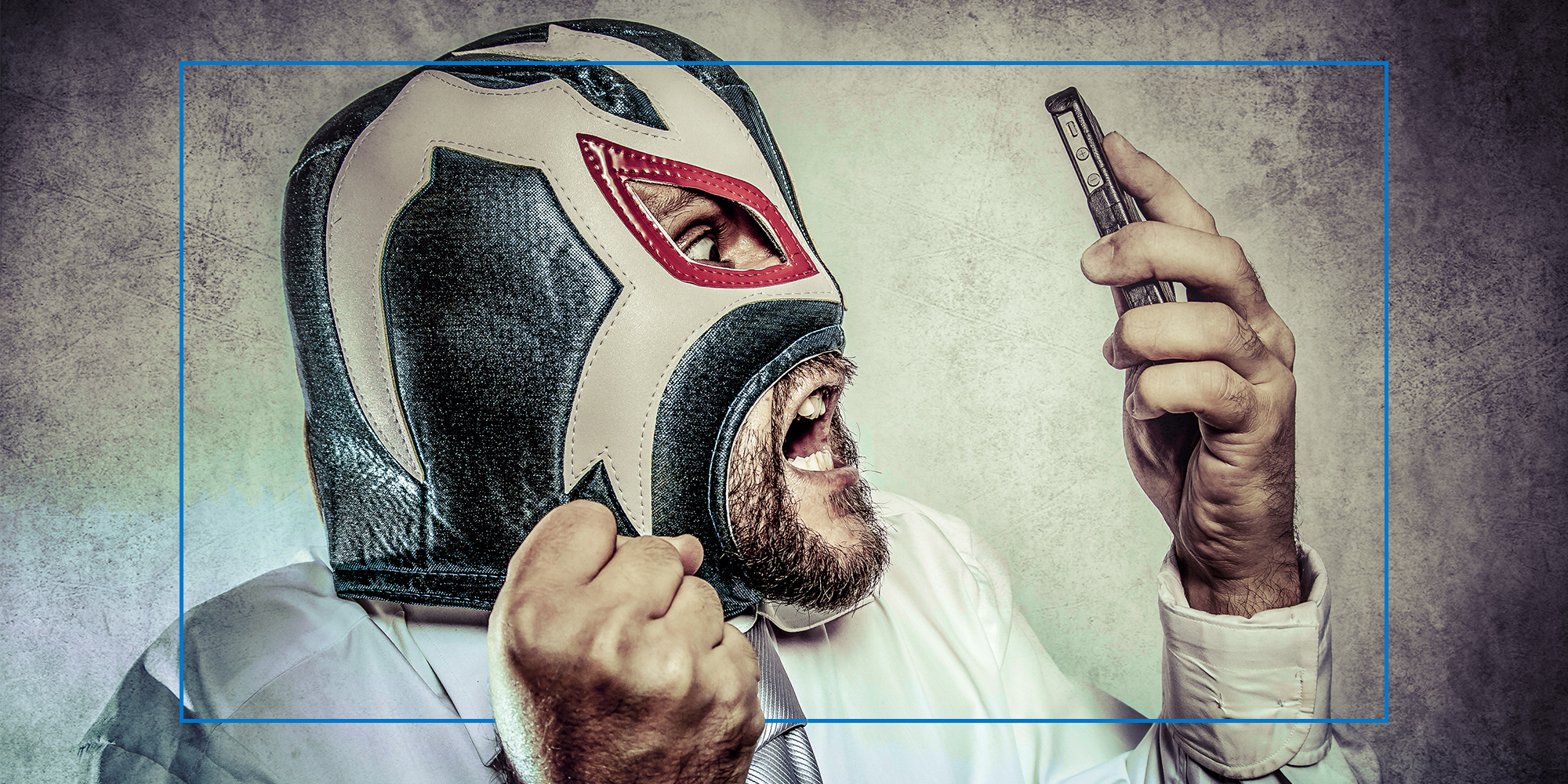 man in luchador mask reacting to phone in hand