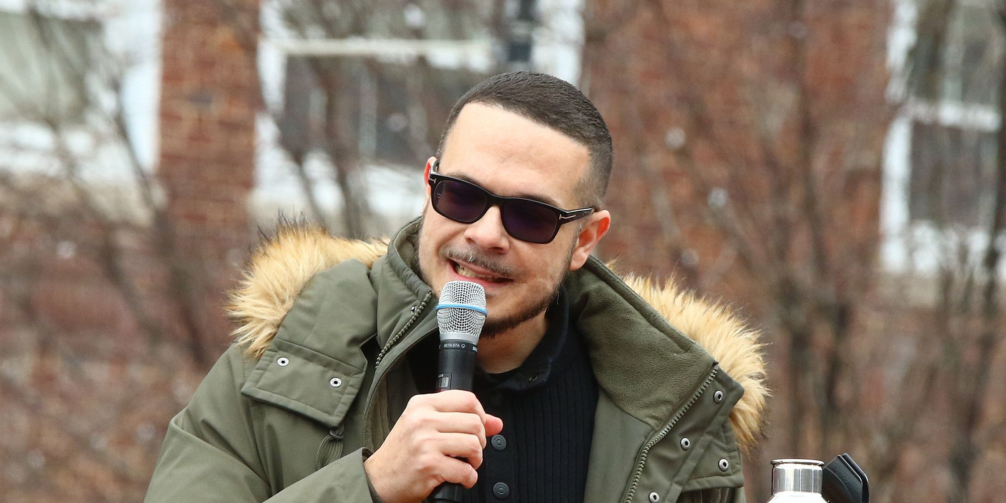 Shaun King speaks into microphone at Bernie Sanders rally.