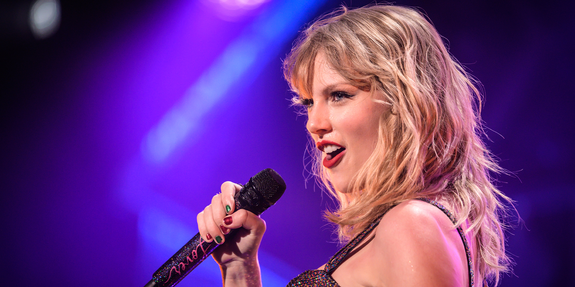 taylor swift holding a microphone during a show