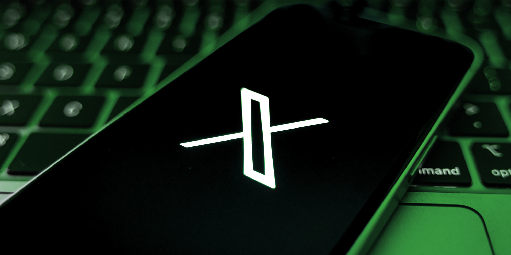 Phone with X app open cast in green light