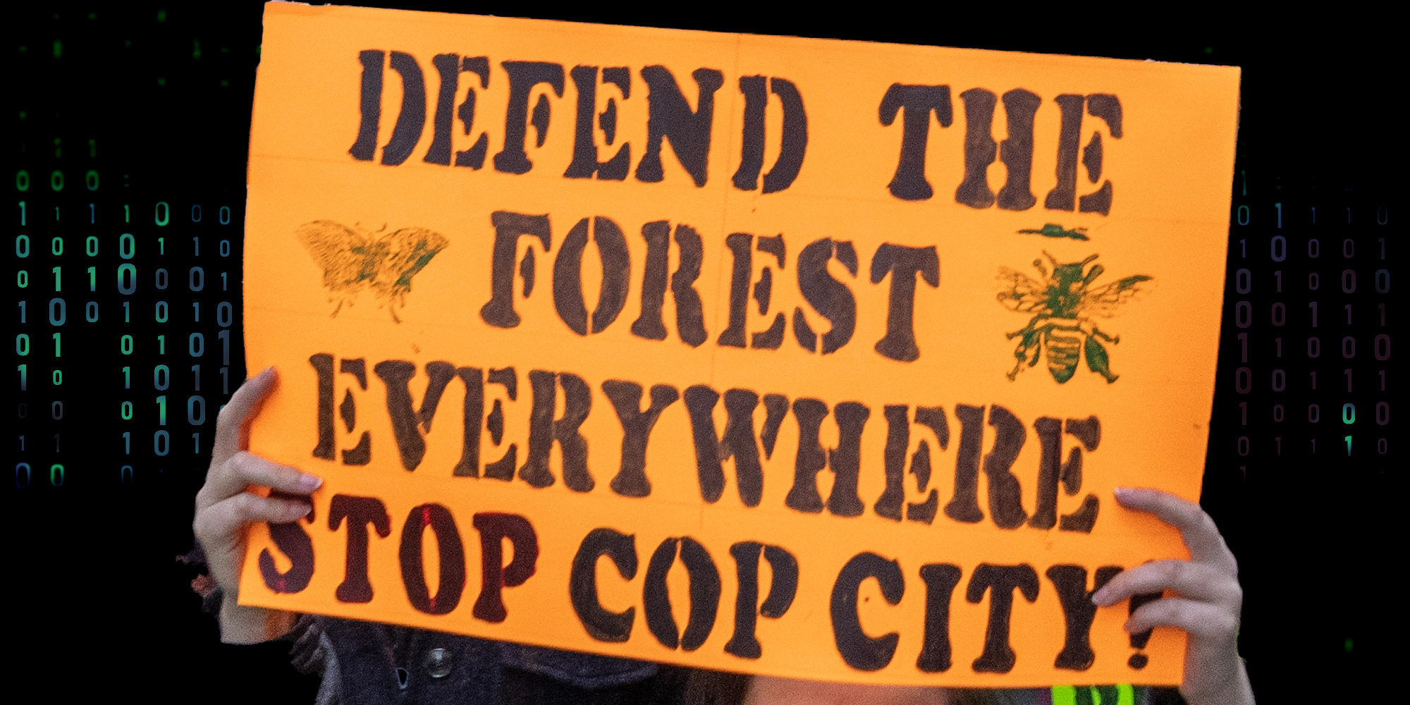 Hands holding stop cop city sign