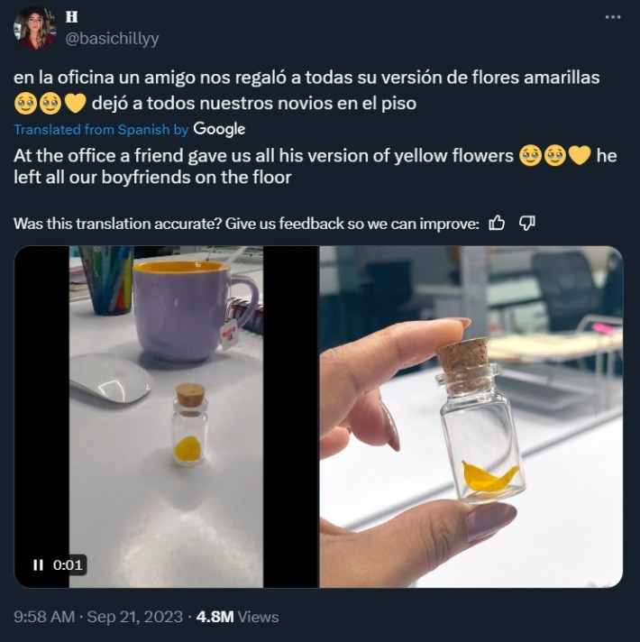 Man leaves a small vial with a yellow flower pedal to female coworkers