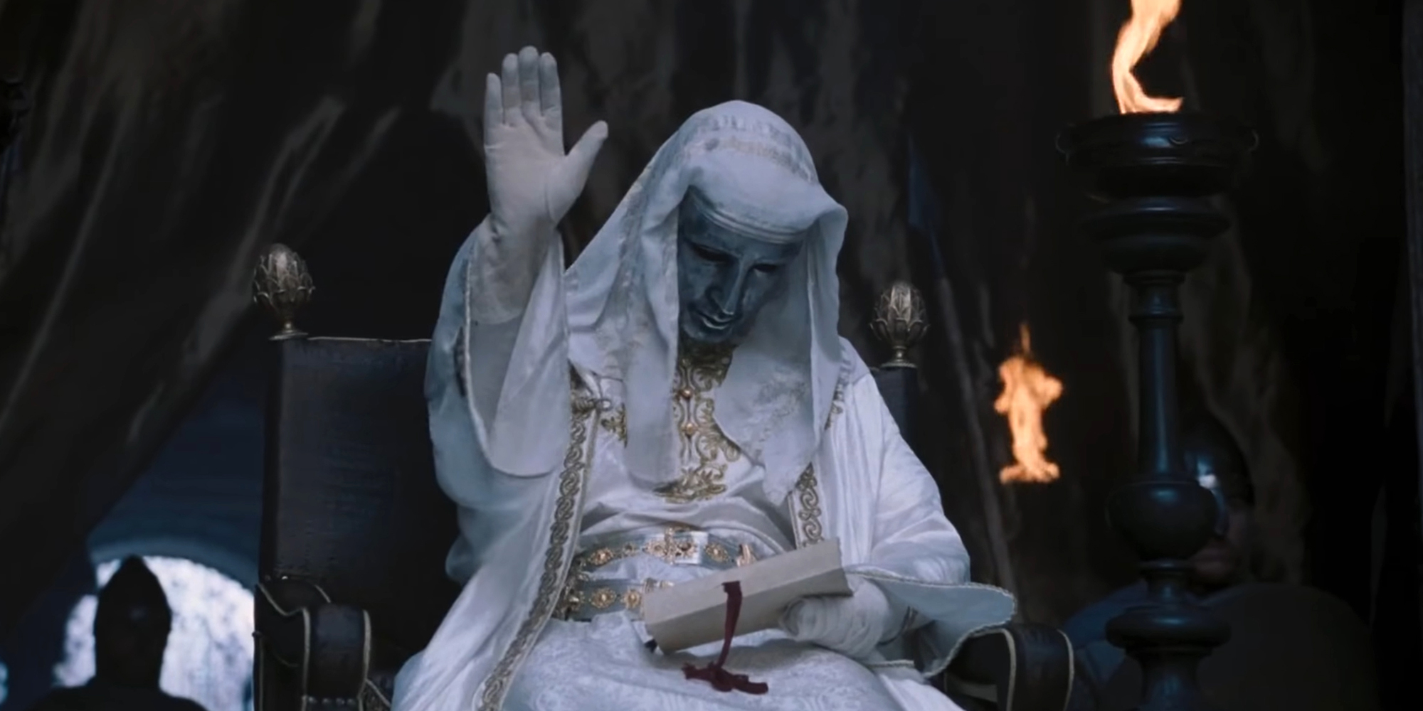 Masked figure with hand raised