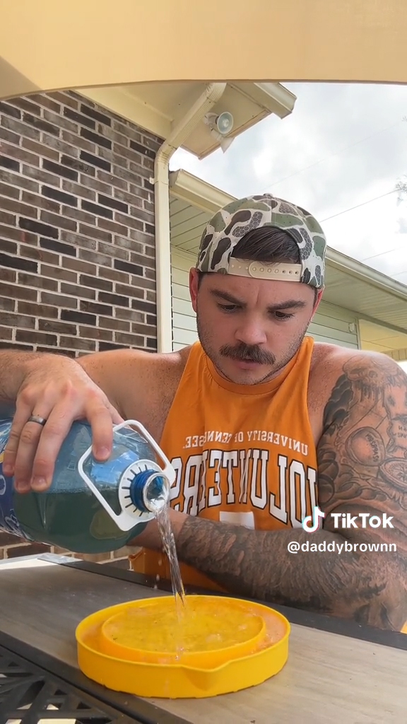 man pouring liquid into plastic container