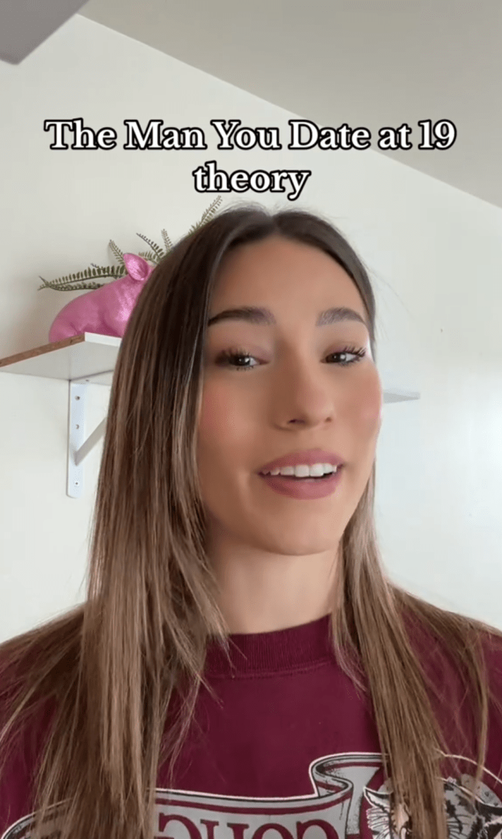 Photo of a woman smiling uncomfortably at the camera. Text overlay reads, "The Man You Date at 19 theory"