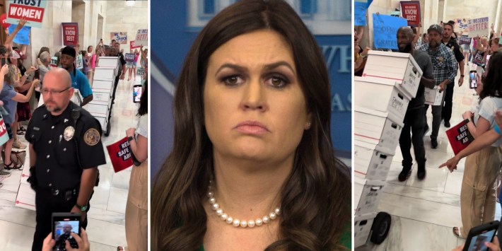 men hand-trucking stacks of boxes into building (l & r) sarah huckabee sanders (c)