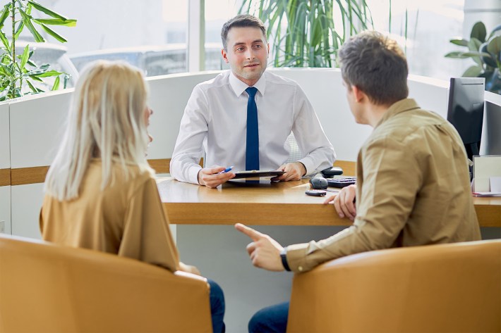 customers came to make purchase in dealership, sit talking with salesman, ask questions about car.