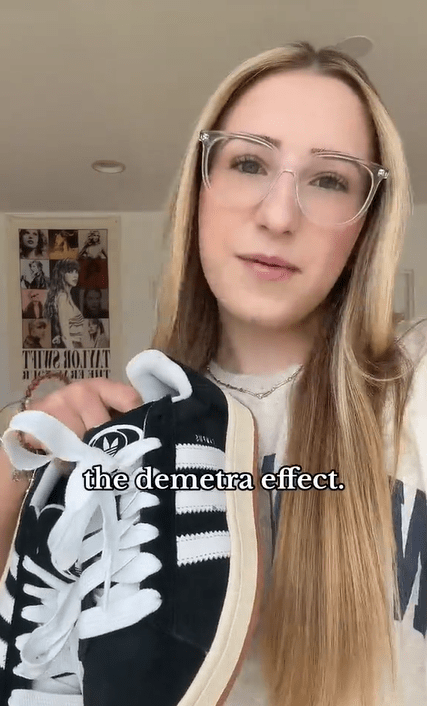 A young blonde woman in big glasses showing off a pair of Adidas in her hand. Text overlay reads, "the demetra effect."