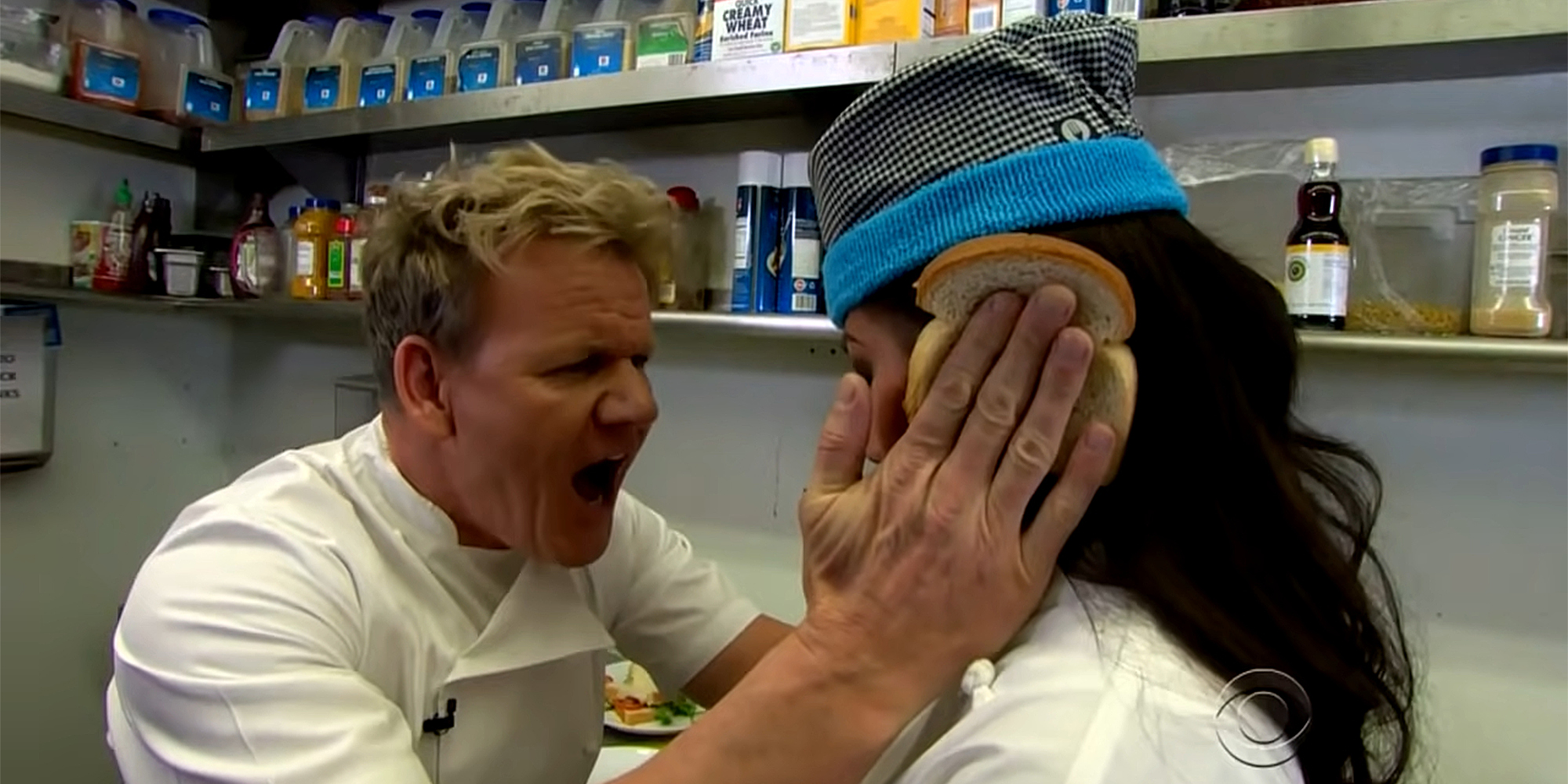 gordon ramsey holding bread over woman's ear in kitchen