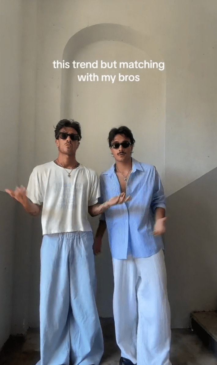 Two men in matching outfits gesturing at the camera. Text overlay reads, "this trend but matching with my bros."