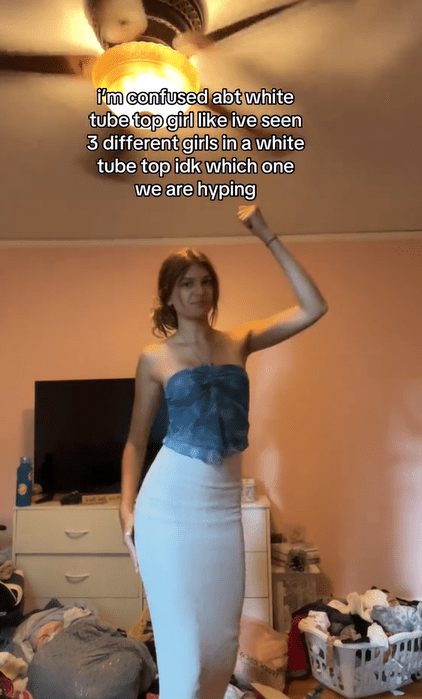 Screenshot of a woman dancing with text overlay that reads, "i'm confused about white tube top girl like ive seen 3 different girls in a white tube top idk which one we are hyping."