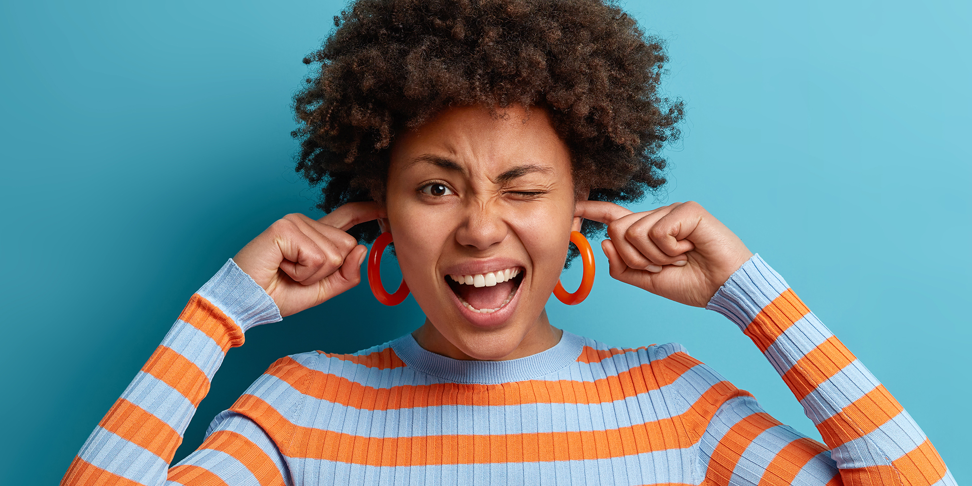 young woman plugs ears