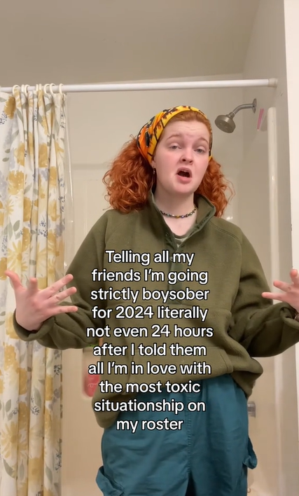 A redhead in slouchy clothing makes a face at the camera. Text overlay reads, "Telling all my friends I'm going strictly boysober for 2024 literally not even 24 hours after I told them all I'm in love with the most toxic situationship on my roster."