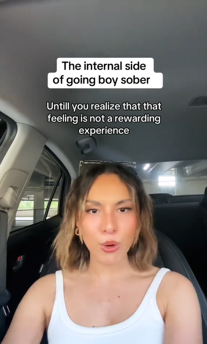 Woman sitting in her car. Text overlay reads, "The internal side of going boy sober." and "Untill you realize that that feeling is not a rewarding experience"