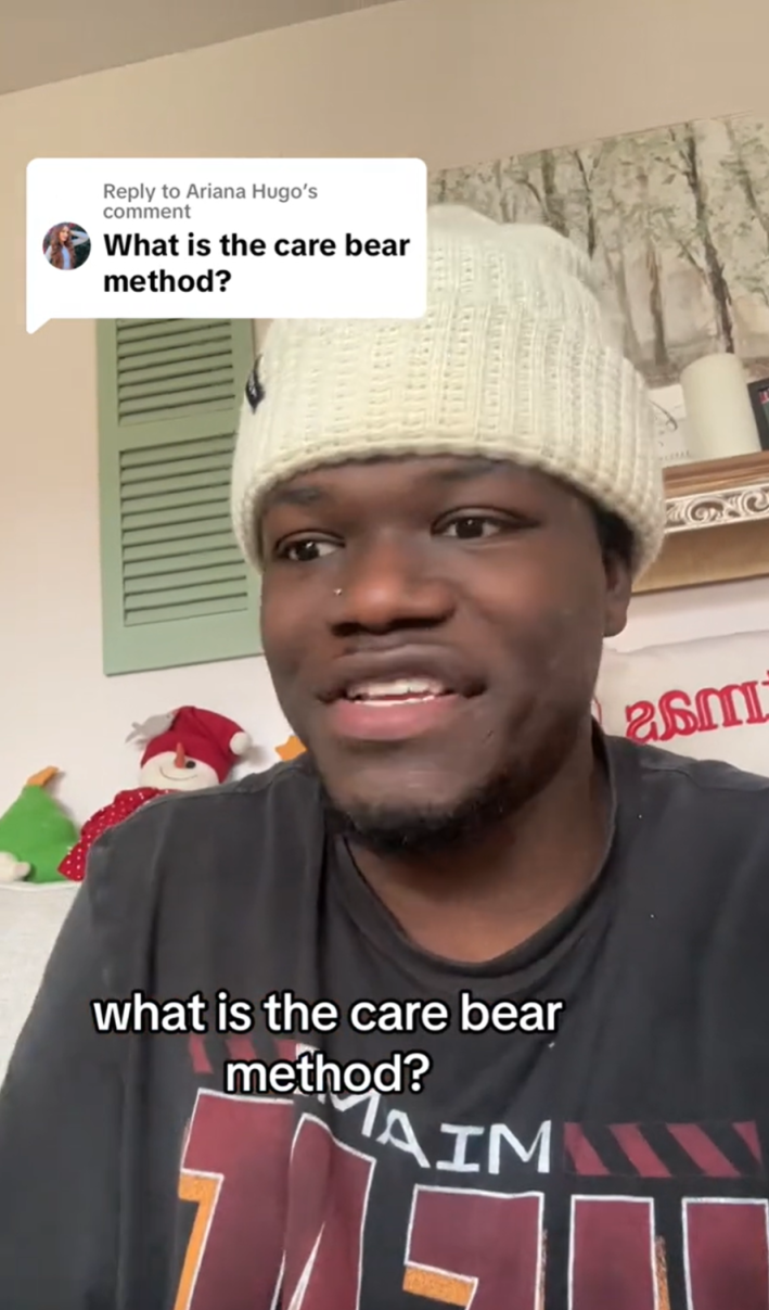 A man in a white beanie staring off to the side. He is replying to a TikTok comment that reads, "What is the care bear method?"