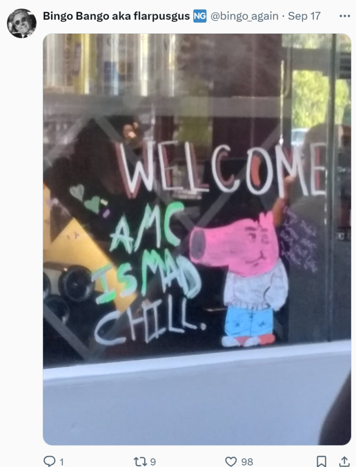 Photo of a storefront window drawing of the My New Character meme. Text on the window reads, "WELCOME AMC IS MAD CHILL."
