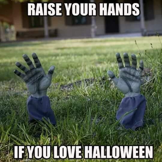 Halloween meme with zombie hands sticking out of grass. Text reads, "Raise your hands if you love Halloween"