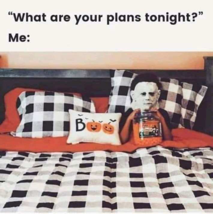 Text reads, "What are your plans tonight? Me:" with a photo of a Halloween-themed bed and someone in a Michael Myers mask under the covers with candy.