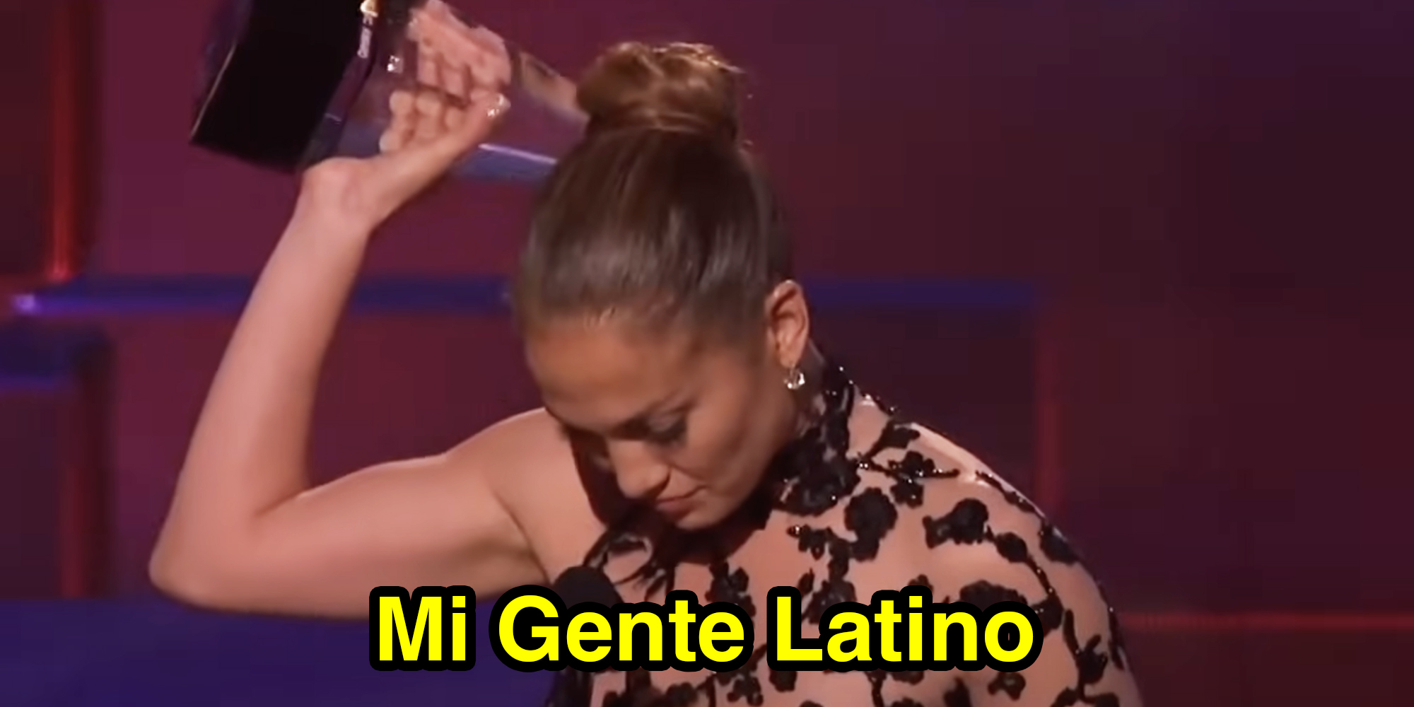 Jennifer Lopez holding trophy over head with text that says "Mi Gente Latino"