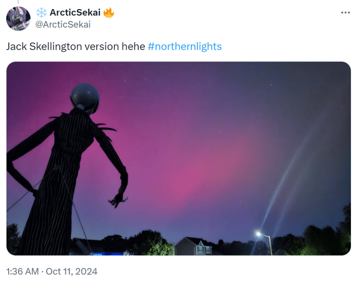 Photo of the northern lights with a Jack Skellington figurine looking at the sky.