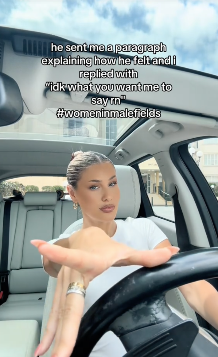 A TikTok video of a woman in her car, smiling at the camera, with the caption "He sent me a paragraph explaining how I felt...etc. #Womeninmalefields"