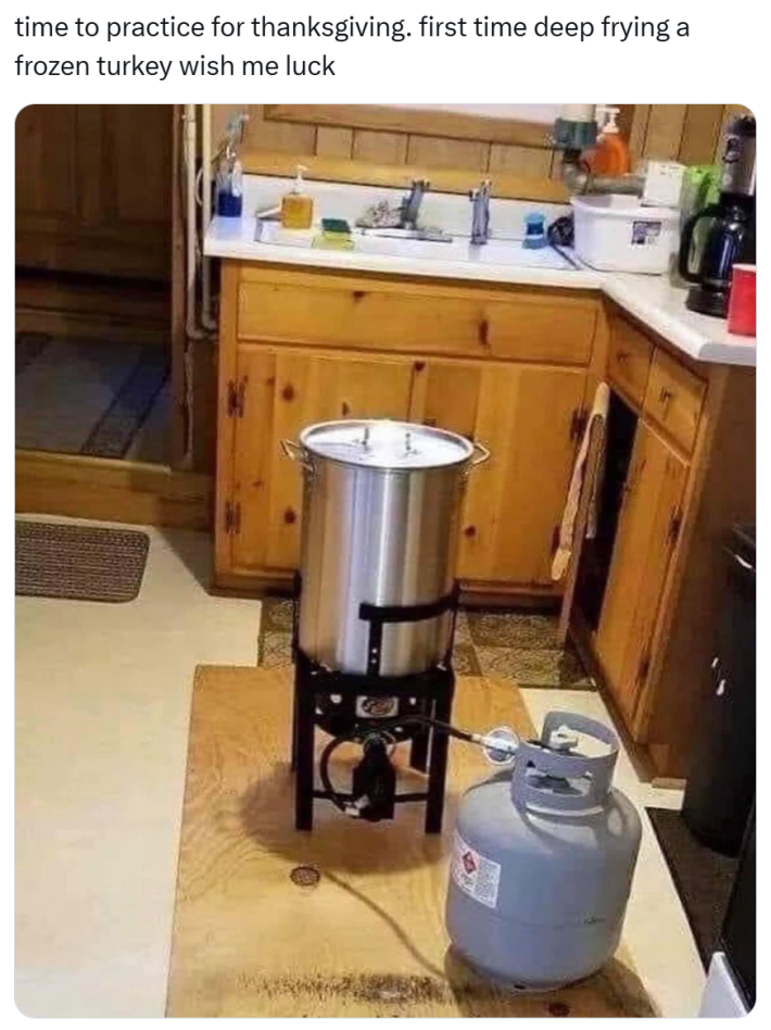 Funny Thanksgiving meme, text reads, "time to practice for thanksgiving. first time deep frying a frozen turkey wish me luck" with a photo of a deep fryer and a propane tank inside a small kitchen.