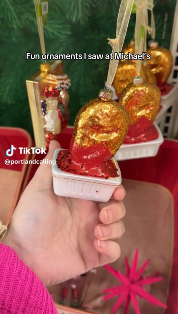 Golden chicken nugget ornament dipped in ketchup in a white container