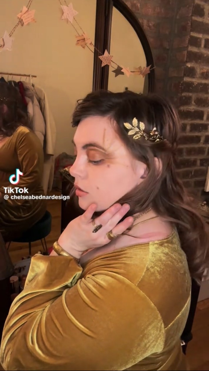 Person with gold headband and dress