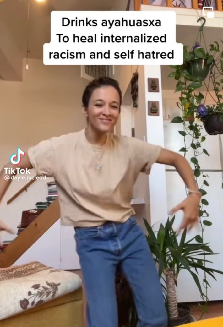 Woman dancing in her living room. Text overlay reads, "Drinks ayahuasxa To heal internalized racism and self hatred."