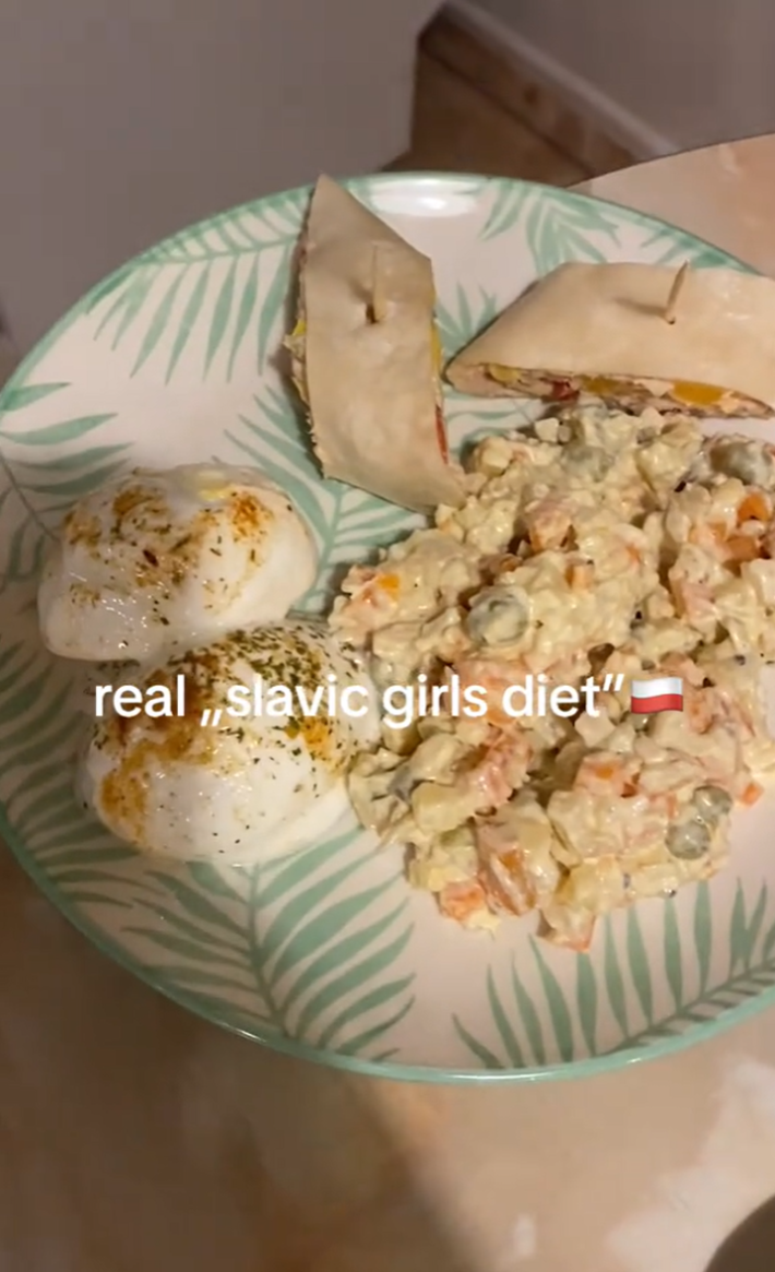 Still of a TikTok with text overlay reading, "real 'slavic girls diet'" with rich and fatty foods on a plate.