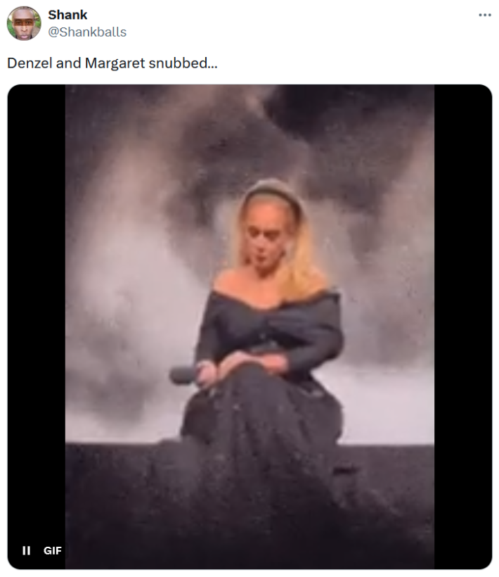 Oscars nominations snubs tweet with a gif of a woman in a gray gown sitting on a smokey stage.