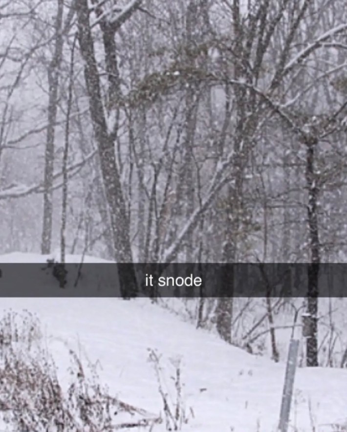 Snapchat photo of snow outside a window. Text overlay reads, "it snode"