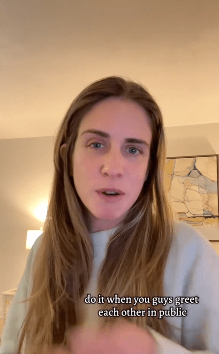 Screenshot of a woman staring at the camera saying, "do it when you guys greet each other in public."