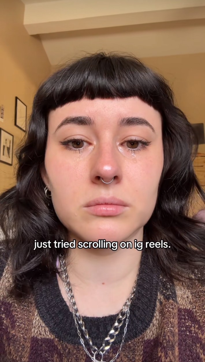 TikTok screenshot of a woman crying into the camera. Text overlay reads, "just tried scrolling on ig reels."