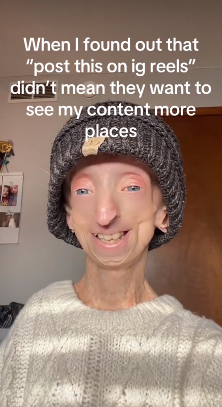 TikTok screenshot of a woman wearing a grey beanie smiling at the camera. Text overlay reads, "When I found out that 'post this on ig reels' didn't mean they want to see my content more places."
