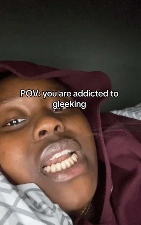 TikTok video of a woman shooting saliva out of her mouth with a caption reading "POV: you are addicted to gleeking."
