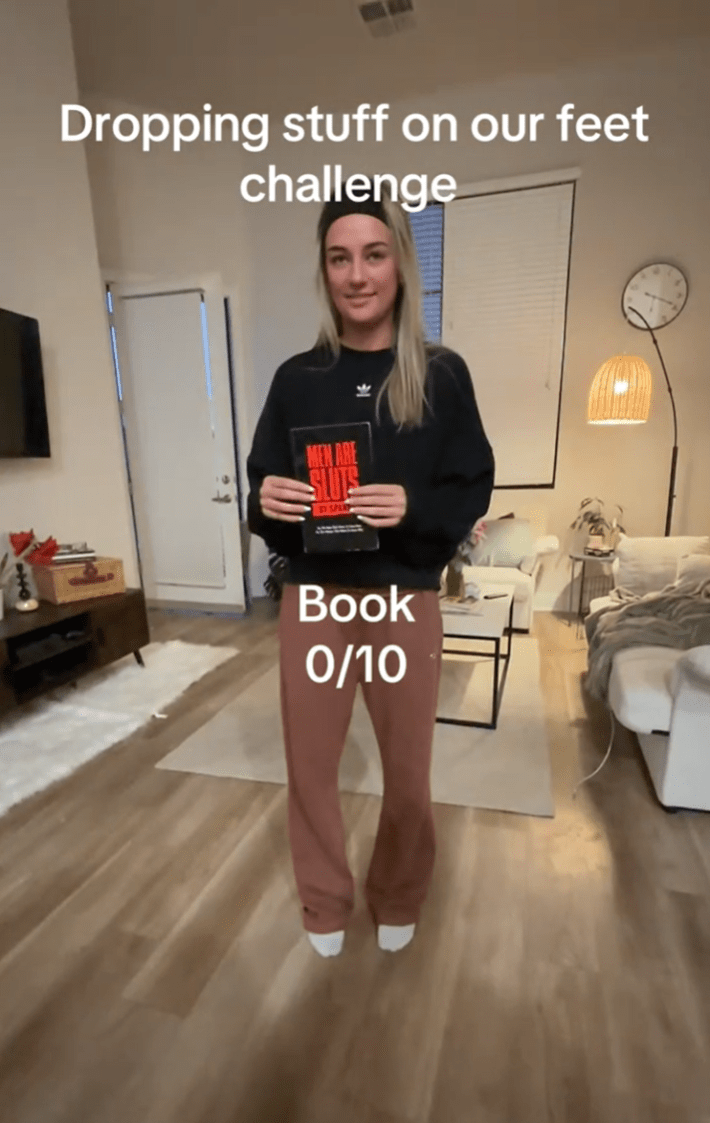 Dropping objects on feet TikTok trend, a woman dropping a book on her foot.