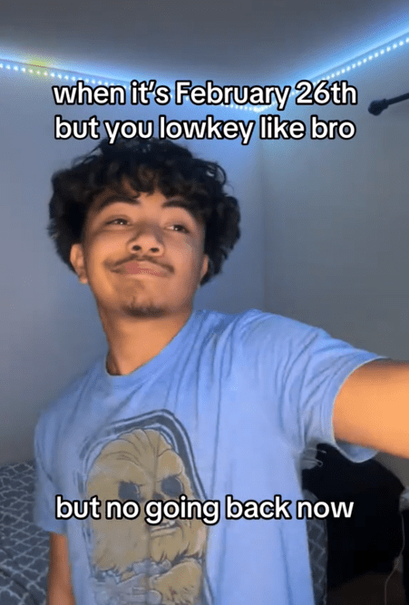 TikTok video of a man smirking and holding out an arm and a caption reading "when it's February 26th but you lowkey like bro, but no going back now."