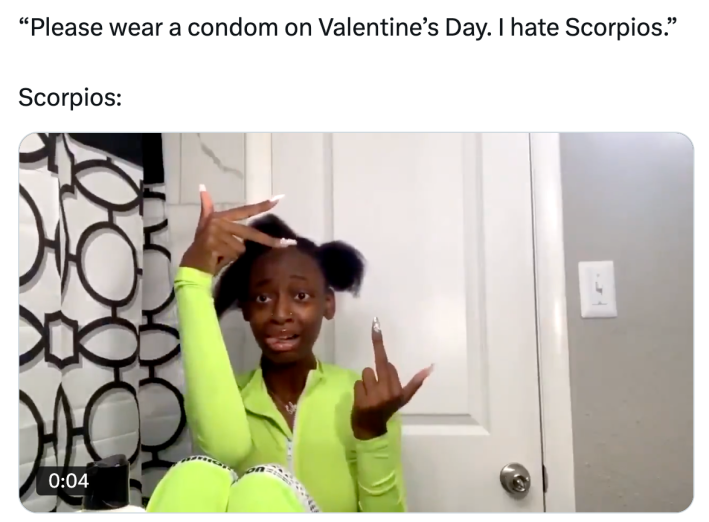 Valentine's Day meme, text reads, "'Please wear a condom on Valentine’s Day. I hate Scorpios.' Scorpios:" with a photo of a girl sitting on a bathroom floor posing for the camera and giving it the finger.