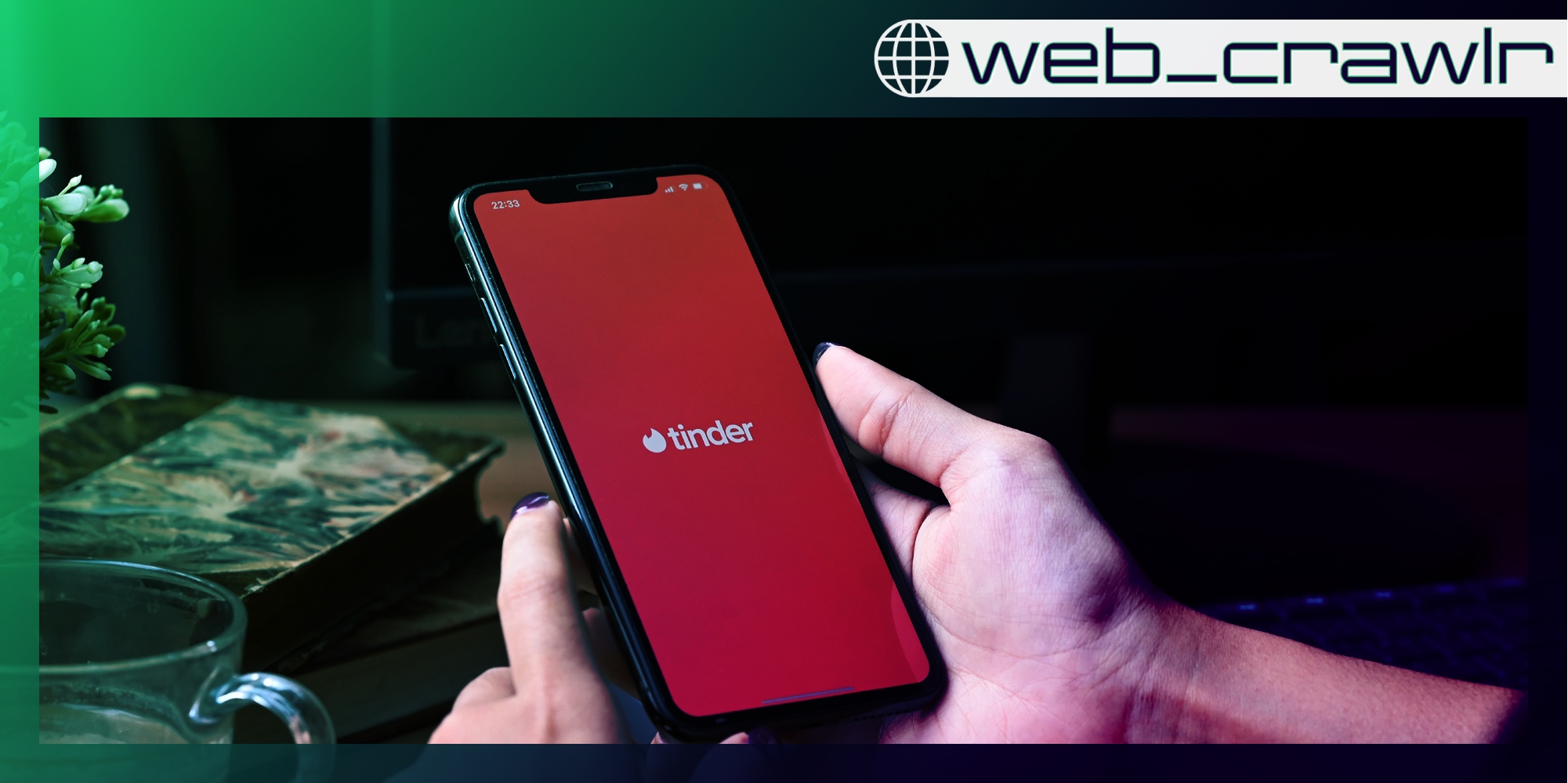 A phone with the Tinder logo on it. The Daily Dot newsletter web_crawlr logo is in the top right corner.