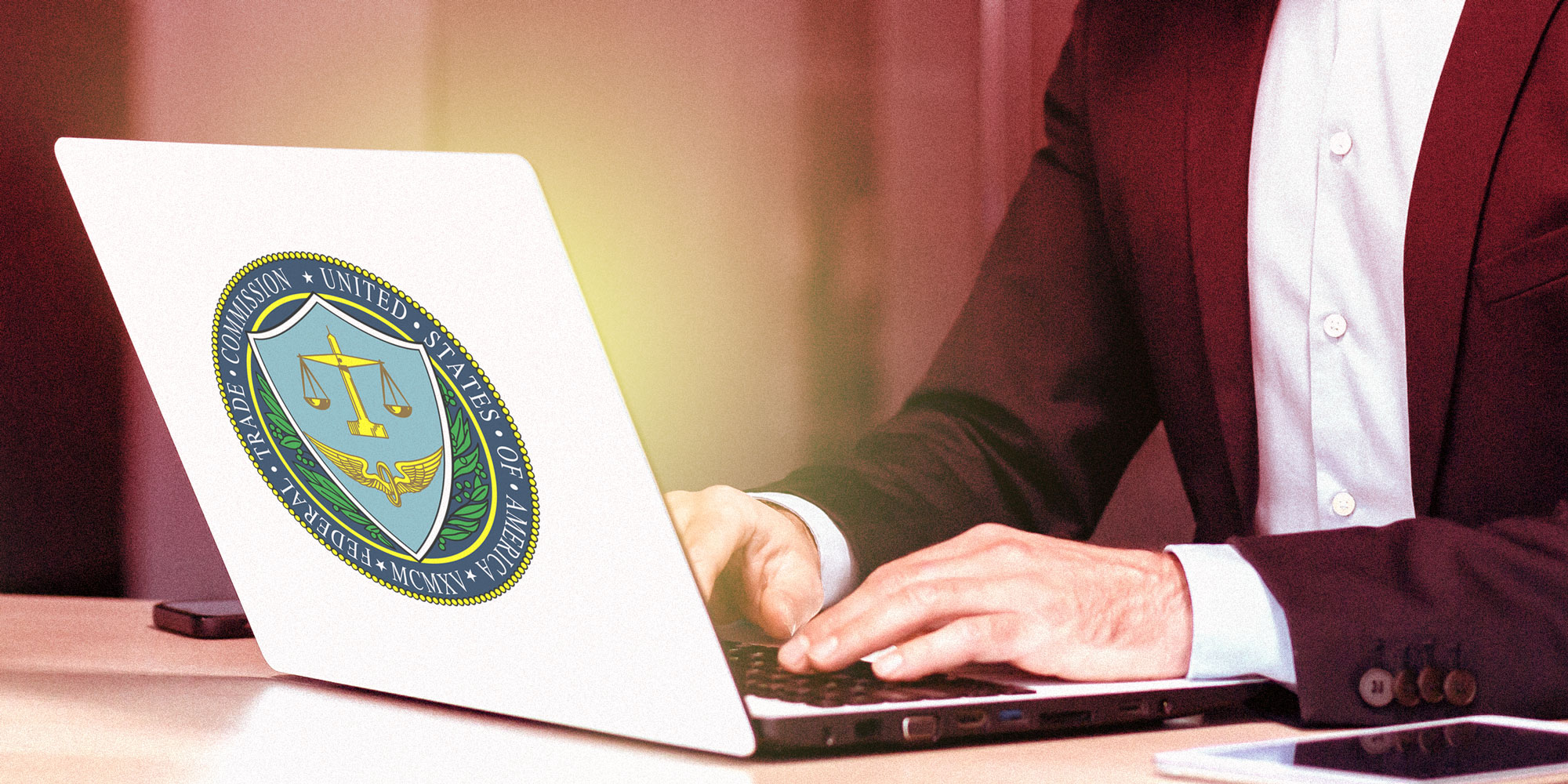 Photo illustration of a faceless man at a laptop with the FTC logo on the back of the laptop.