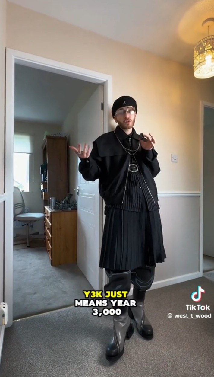 Y3K style with black jacket, kilt, and chunky boots