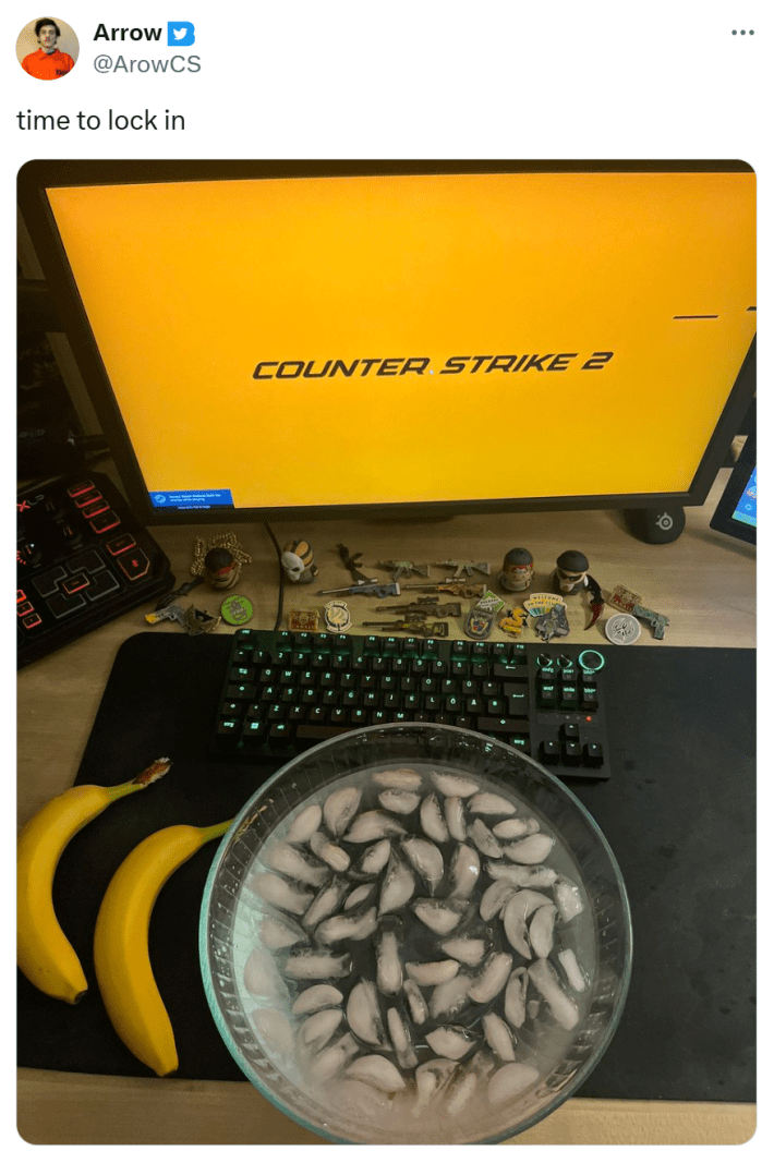 Saratoga water meme, text reads, "time to lock in" with counter strike on the computer and a bowl of ice water and bananas on the desk in front of them.